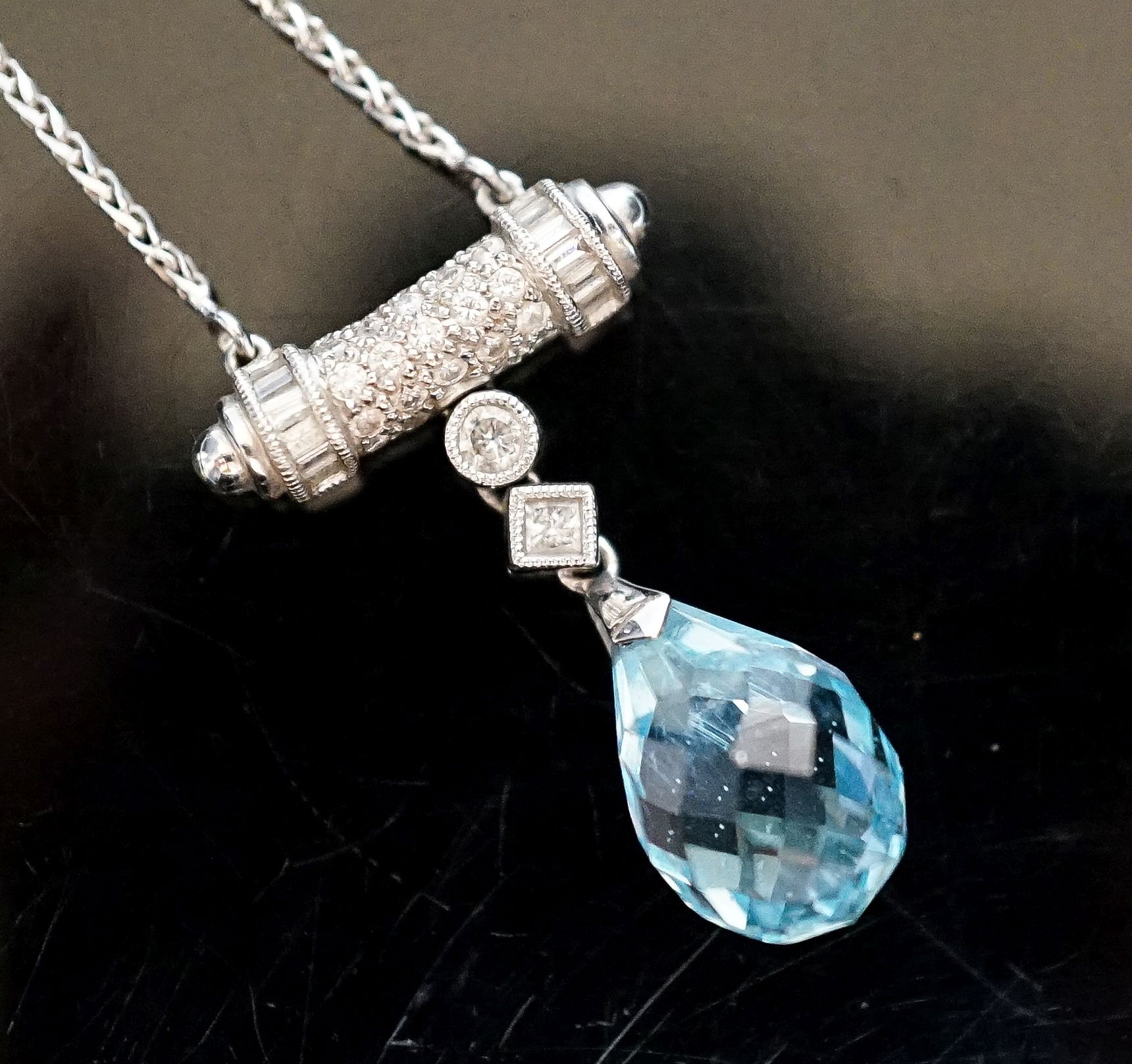 A modern 750 white metal, facet cut pear shaped aquamarine and diamond chip set drop pendant, pendant 25mm, chain 40cm, gross weight 6.2 grams.